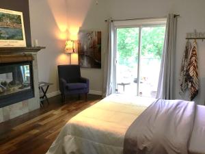 a bedroom with a bed and a fireplace and a window at Quiet Cozy Luxury on the Thames in Ontario! in London