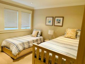 a bedroom with two beds and a window at Qualicum Landing West Coast Cottage in Qualicum Beach