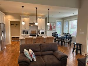 a living room and kitchen with a couch and a table at Qualicum Landing West Coast Cottage in Qualicum Beach