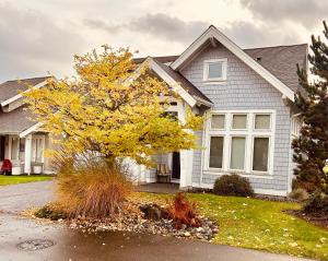 a house with a yellow tree in the front yard at Qualicum Landing West Coast Cottage in Qualicum Beach