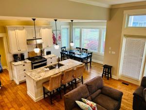 a kitchen and a living room with a table at Qualicum Landing West Coast Cottage in Qualicum Beach +7 photos