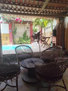 a patio with chairs and a table and a pool at Casa Boa Venttura Alugueis - Casa com ar e piscina ou Quartos com ar e cozinha Guajiru Trairi in Trairi
