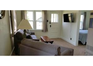 a living room with a couch and a television at #7 Kipling Cottages Last Resort on Lake Michigan in Gladstone