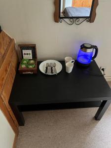 a black table with a plate and cups on it at aba ZARA in Hamburg
