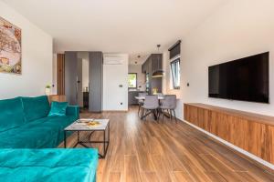 a living room with a green couch and a flat screen tv at Luxury Villa MAJA in Baška Voda