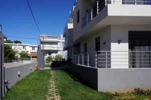 a house with a grass yard next to a building at H residence 2 in Artemida