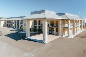 a large building with columns and a roof at Super 8 by Wyndham Jackson MS Near the Fairgrounds in Jackson
