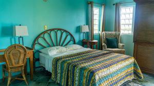 a bedroom with blue walls and a bed and a chair at Lamblion Holiday Apartment in Freemans