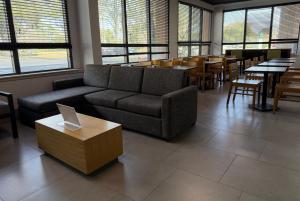 a living room with a couch and tables and chairs at Wingate by Wyndham Jacksonville FL in Jacksonville