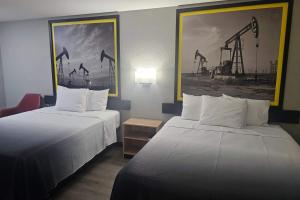 a hotel room with two beds and a painting of a crane at Super 8 by Wyndham Hobbs in Hobbs