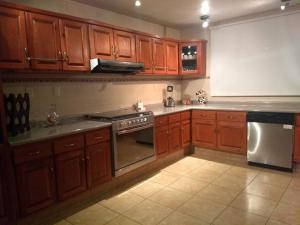 a kitchen with wooden cabinets and a stove top oven at Casa en Xochimilco in Mexico City