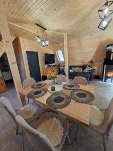 a dining room with a wooden table and chairs at Escape Remeti - Aframe by the River in Remeţi
