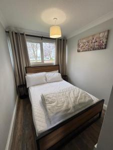 a bedroom with a bed with white sheets and a window at 88, Two bed Chalet on Belle Aire Holiday Park - sleeps 5, pet friendly, bed linen and towels included plus onsite entertainment available in Great Yarmouth