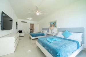 a bedroom with two beds and a television in it at Sea Winds Cabarete in Cabarete
