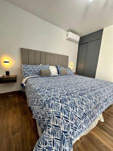 a bedroom with a bed with a blue and white comforter at AR SUITES Casa Luneta in Zamora de Hidalgo