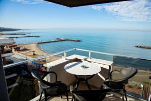 a balcony with a table and chairs and the ocean at Sofia Beach Residence in Trabzon