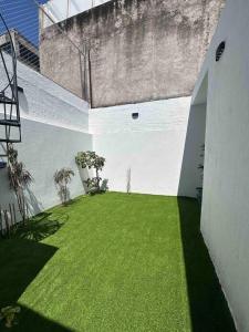an open courtyard with green grass in a building at AR SUITES Casa Luneta in Zamora de Hidalgo