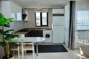 a kitchen with a table and a white refrigerator at Sofia Beach Residence in Trabzon +8 photos