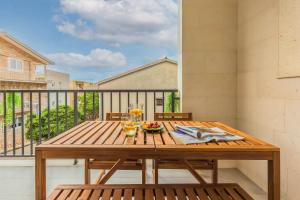 a wooden table with a bowl of fruit on a balcony at Luxury Villa MAJA in Baška Voda