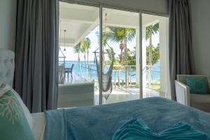 a bedroom with a bed and a view of the ocean at Sea Winds Cabarete in Cabarete +33 photos