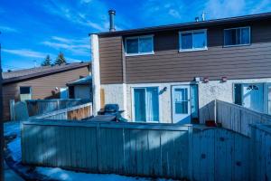 a house with a fence in front of it at Charming 2-Bedroom House in Central Calgary in Calgary