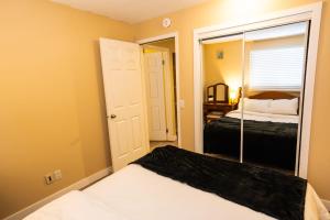 a small bedroom with a bed and a mirror at Charming 2-Bedroom House in Central Calgary in Calgary