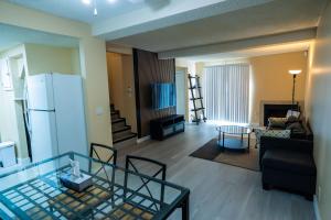 a living room with a glass table and a refrigerator at Charming 2-Bedroom House in Central Calgary in Calgary