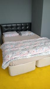 two beds in a room with a black leather headboard at Huzur10 in Edirne +1 photo