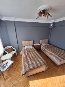 a room with two beds and a table and chairs at Huzur10 in Edirne