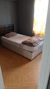 a bed in a room with a wooden floor at Huzur10 in Edirne