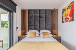 a bedroom with a bed with a large headboard at Luxury Villa MAJA in Baška Voda +47 photos