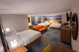 a hotel room with two beds and a couch at Days Inn by Wyndham Sturgis SOUTHDAKOTA in Sturgis