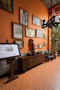 a living room with a wall with pictures on it at Hacienda Gobernadores Boutique Stay in a Historic 19th-Century Hacienda in Mexico City