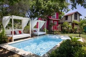a pool with a gazebo and a house at Tiny Village Cartagena Boutique Resort in Tierra Bomba