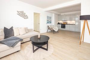 a living room with a white couch and a table at Ostsee Suite 2 - Penthouse in Niendorf +11 photos