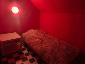 a red room with a bed and a table at Diana Apartments in Klingenthal