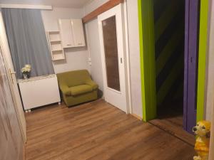 a hallway with a green chair in a room at Diana Apartments in Klingenthal
