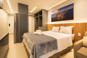a bedroom with a large bed and a couch at Art studio open space in Água Boa