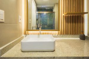 a white sink in a bathroom with a mirror at Art studio open space in Água Boa +13 photos