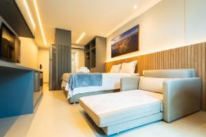 a hotel room with two beds and a couch at Art studio open space in Água Boa