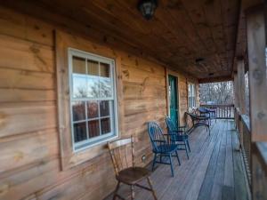 a porch of a wooden cabin with chairs and a window at Haven View Retreat in White Haven
