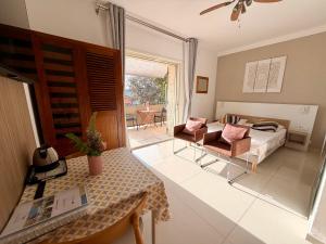a living room with a bed and a couch and a table at Villa Grand Baie in Agay - Saint Raphael