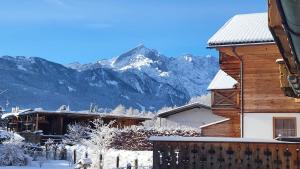 a wooden house with mountains in the background at Chalet Sonnenbichl in Garmisch-Partenkirchen