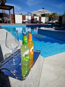two bottles and glasses on a tray next to a swimming pool at Luxury Villa Elements - Novalja in Novalja