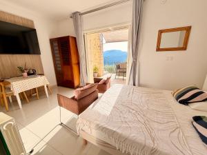 a bedroom with a bed and a table and a window at Villa Grand Baie in Agay - Saint Raphael
