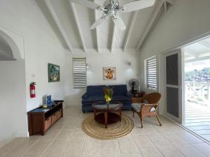 a living room with a blue couch and a table at Oasis Marigot Bay in Marigot