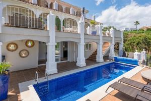 a large house with a swimming pool in front of a house at Casa Lorna in Marbella