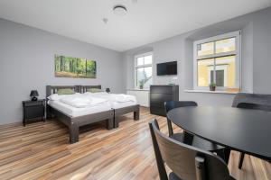a bedroom with two beds and a table and chairs at Penzion, restaurant Gloria in Chrastava