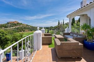 a balcony with wicker furniture and a view of a hill at Casa Lorna in Marbella