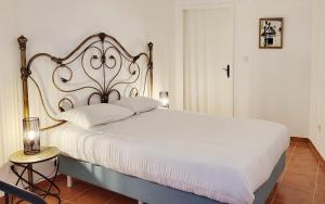 ein Schlafzimmer mit einem großen weißen Bett und einem Nachttisch in der Unterkunft Casa Yalbash in Elvas